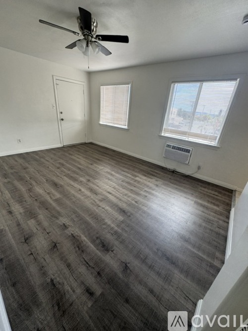 A room with a ceiling fan and a window with blinds.