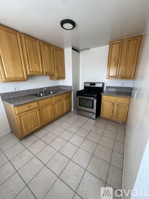 A kitchen with wooden cabinets and a black stove top oven.