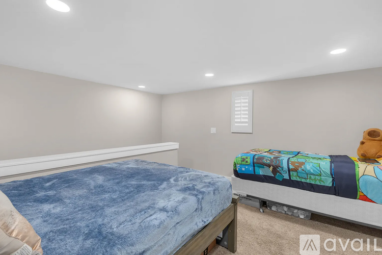 A bedroom with a bed and a blue bedspread.