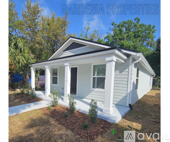 A small white house with a porch is for sale.