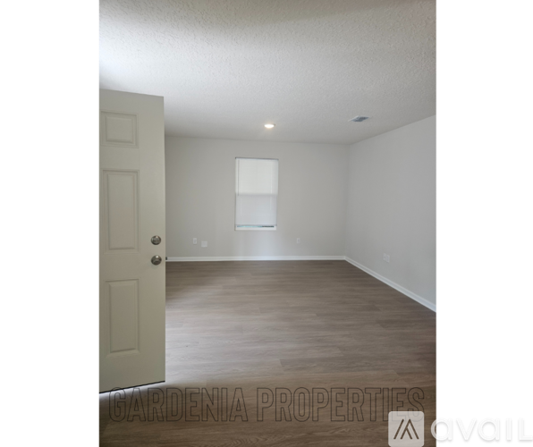 A room with a door and a window, and a sign that says "GARDENIA PROPERTIES available".
