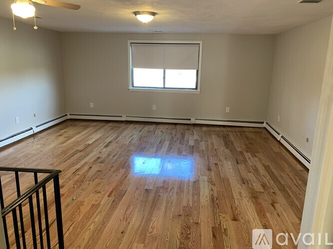 A room with wooden flooring and a window.