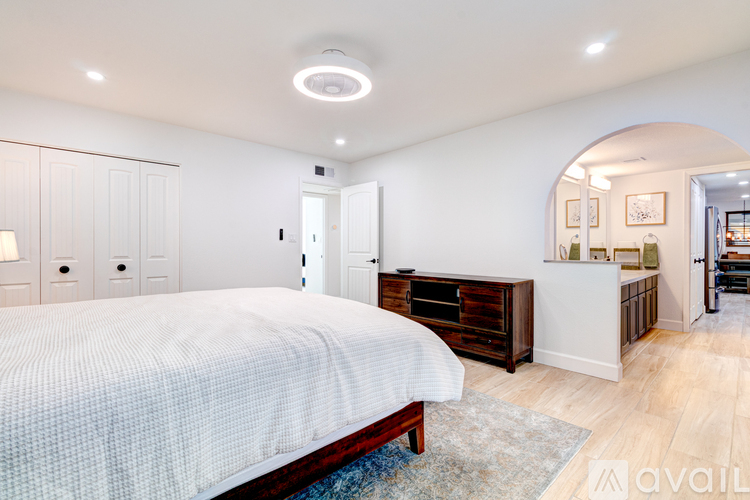 A bedroom with a large bed and a dresser.