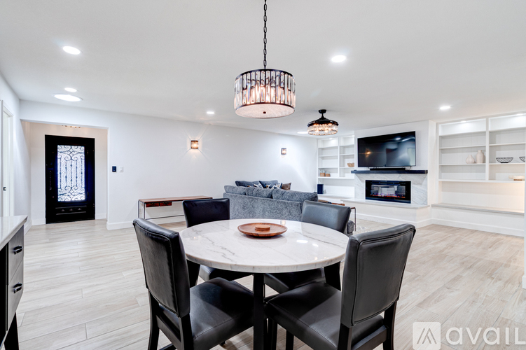 A modern dining room with a round table and chairs.
