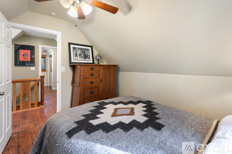 A bedroom with a bed covered in a black and white patterned blanket.