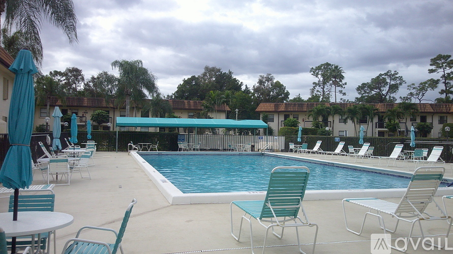 A pool area with chairs and umbrellas is available for use.