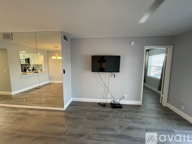 A spacious living room with a flat screen TV mounted on the wall.