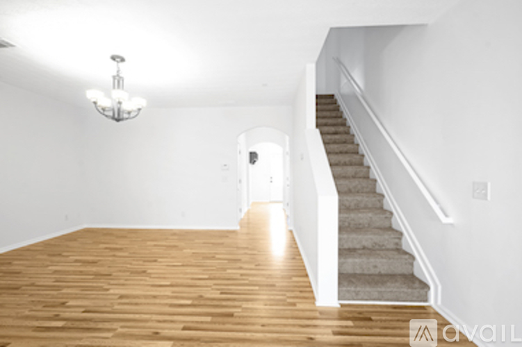 A room with wooden floors and a staircase.