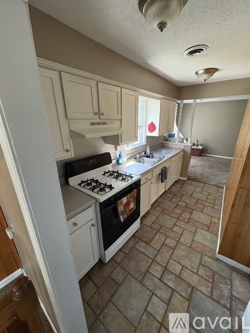 A kitchen with a white stove top oven and a white fridge.