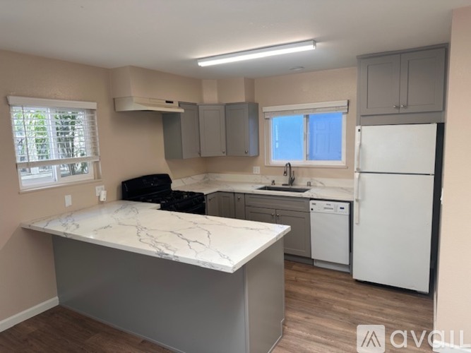 A kitchen with a white countertop and a white refrigerator.
