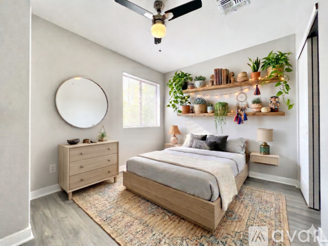 A bedroom with a bed, a dresser, and a ceiling fan.