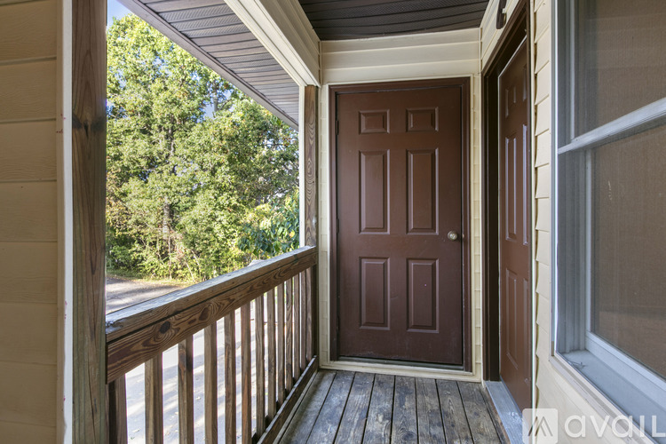 A brown door is on the porch of a house.