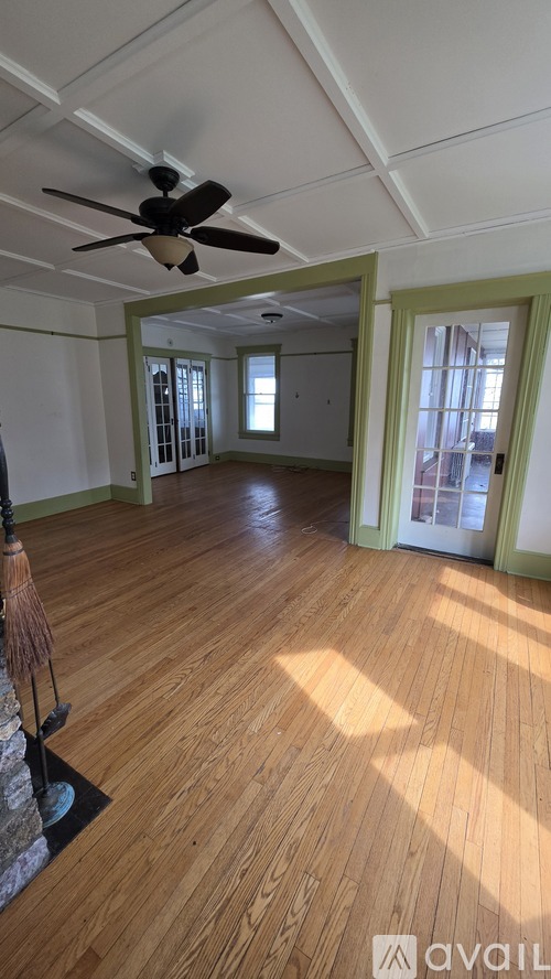 A room with wooden floors and a ceiling fan.