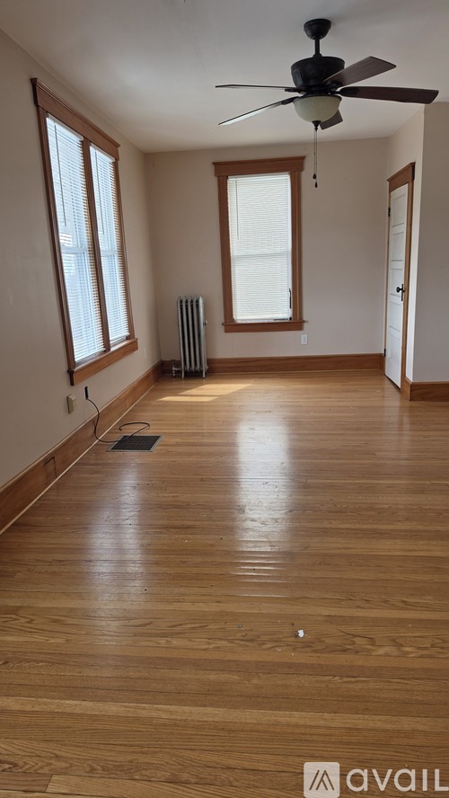 A room with wooden floors and a ceiling fan.