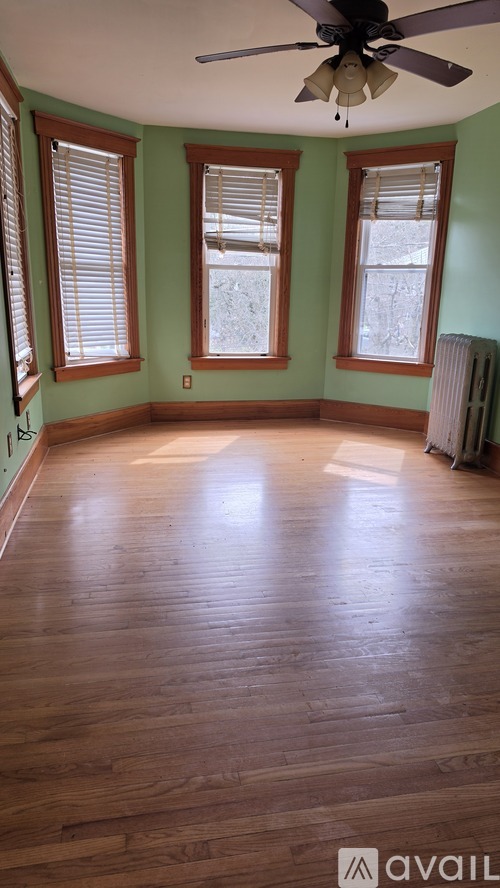 A room with wooden floors and a ceiling fan.