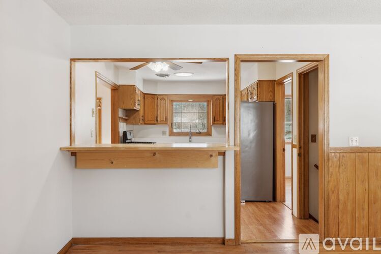 A kitchen with wooden cabinets and a white wall.