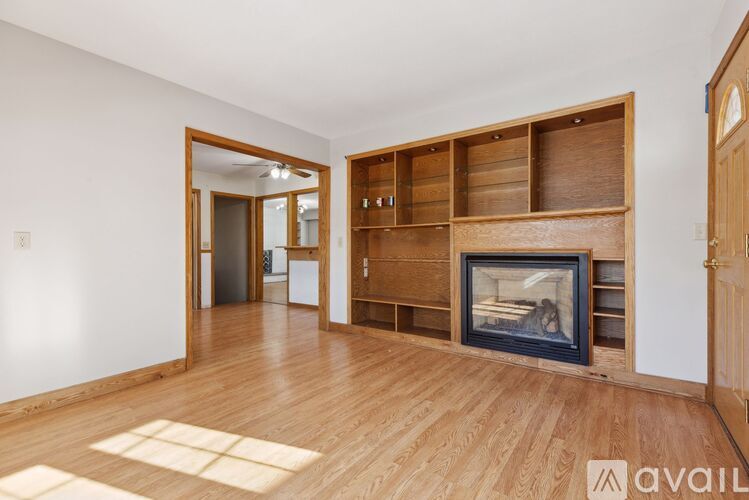 A spacious living room with a fireplace and built-in shelves.