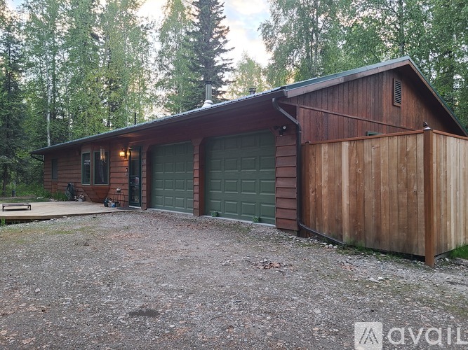 A wooden house with a green garage door.