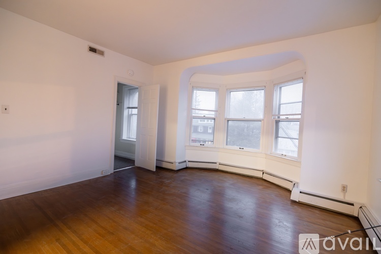 A large empty room with wooden floors and white walls.