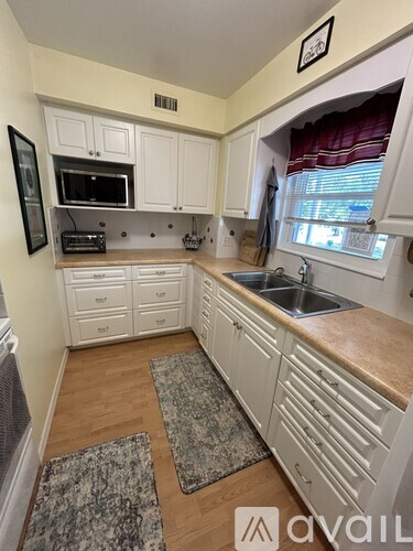 A kitchen with white cabinets and a granite countertop.