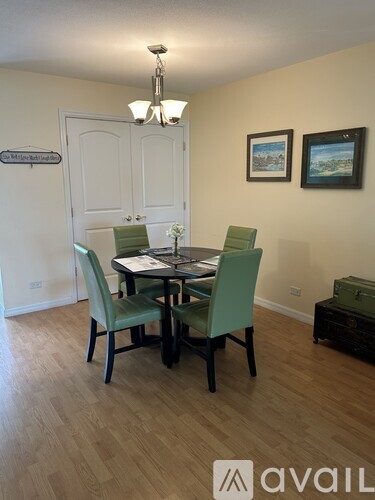 A dining room with a table and chairs.