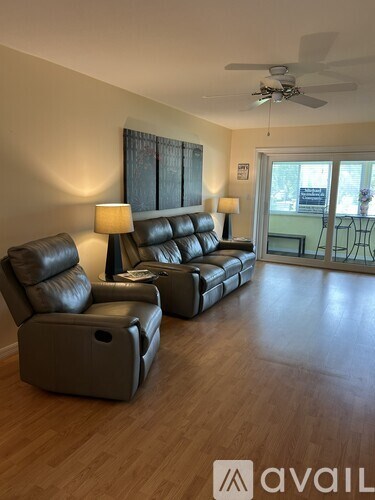 A living room with two leather sofas and a table with a lamp.