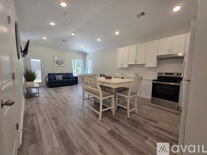 A kitchen with a dining table and chairs in the middle of the room.