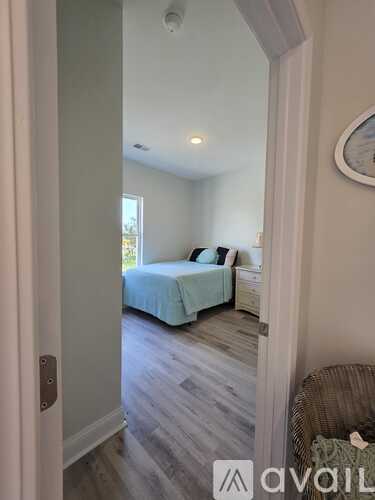A bedroom with a bed and a wicker chair.