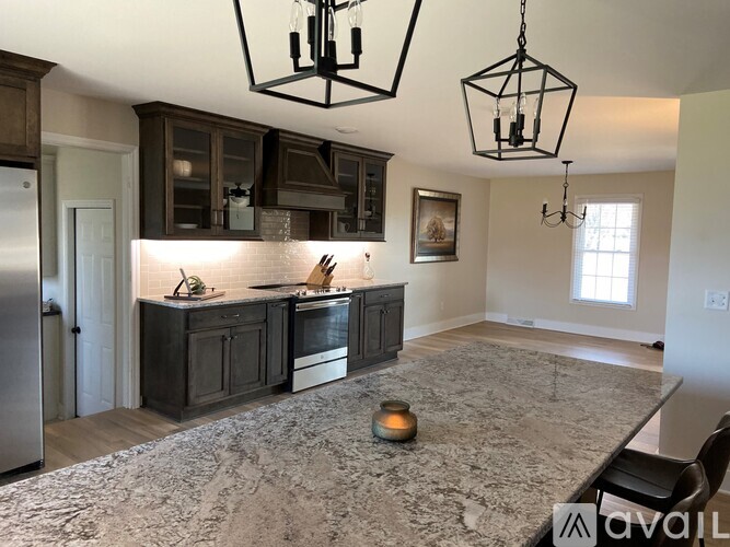 A kitchen with a marble floor and a framed picture on the wall.