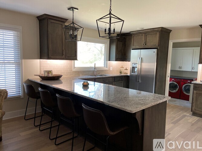 A kitchen with a large island and chairs.