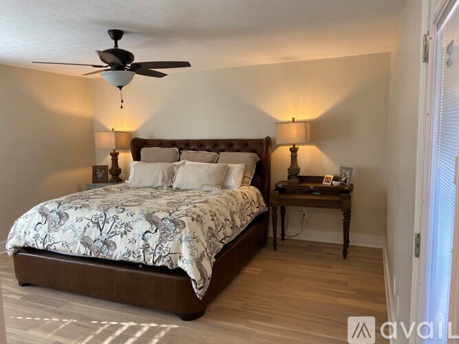 A bedroom with a large bed and a ceiling fan.
