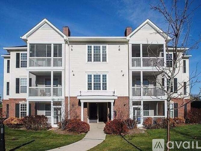 A large white building with a balcony on the second floor.