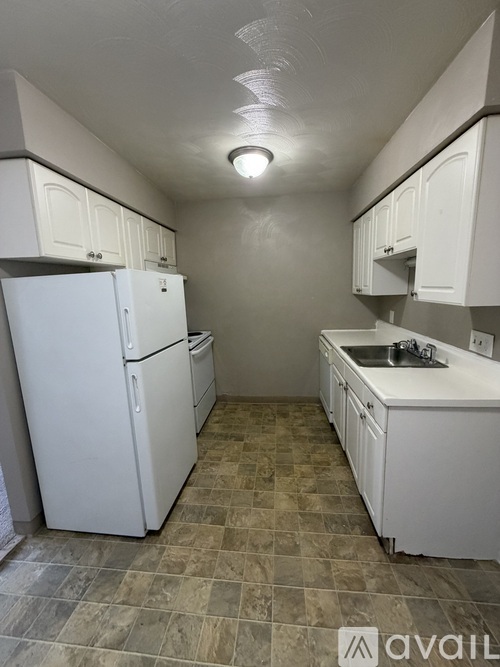 A kitchen with white appliances and cabinets.