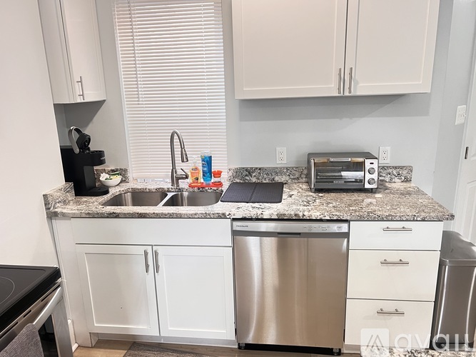 A kitchen with a sink, dishwasher, and microwave.