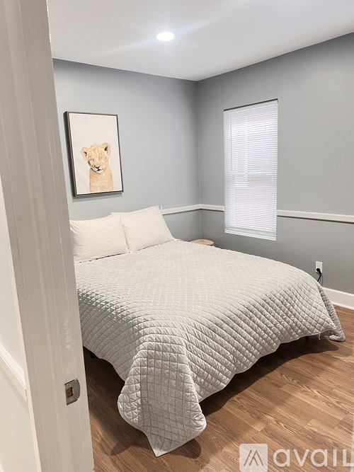A bedroom with a bed and a picture of a lion on the wall.