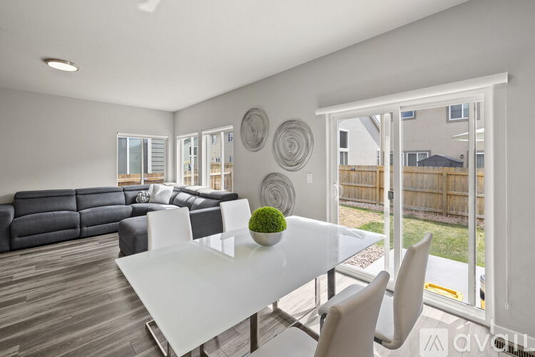 A modern dining room with a white table and chairs.