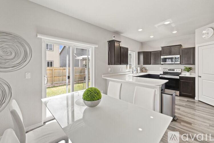 A modern kitchen with a white dining table and chairs.