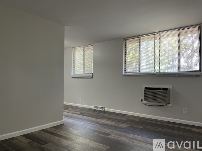 A room with a window and a wall-mounted air conditioner unit.