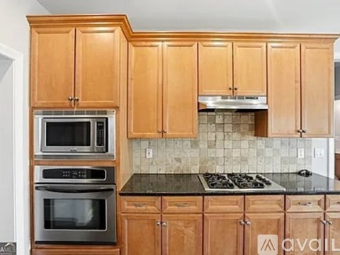 A kitchen with wooden cabinets and a black countertop.