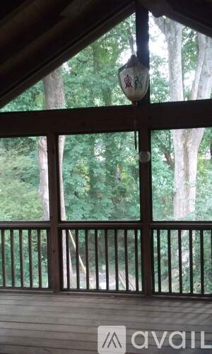 A balcony with a railing and a view of trees.