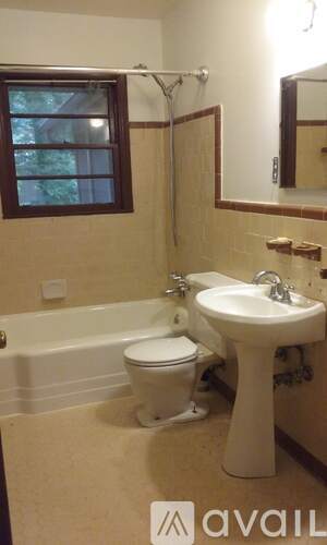 A bathroom with a toilet, sink, and bathtub.