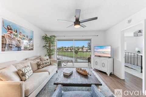 A living room with a couch, a coffee table, a television, and a painting on the wall.