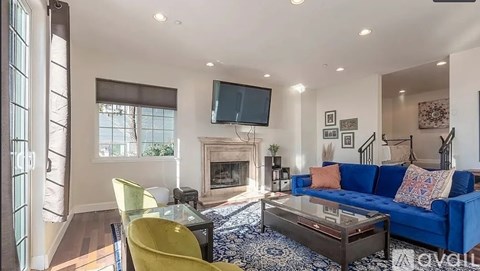 A living room with a blue couch and a fireplace.