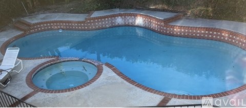 A small pool with a hot tub in the middle.