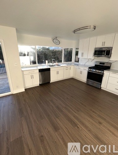 A kitchen with white cabinets and a black stove top oven.