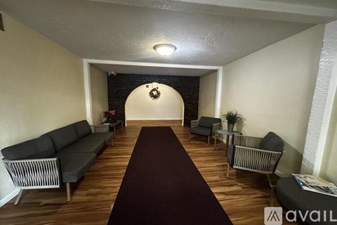 A living room with a long couch and a wreath on the wall.