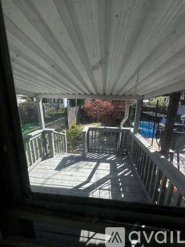 A view from inside a building looking out to a deck with a railing.