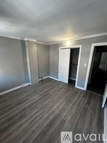 A room with wooden flooring and a white door.