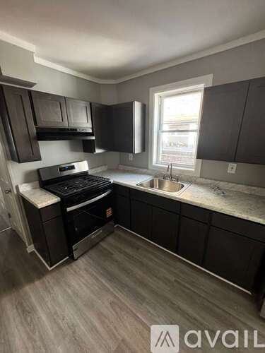 A kitchen with dark wood cabinets and a white countertop.