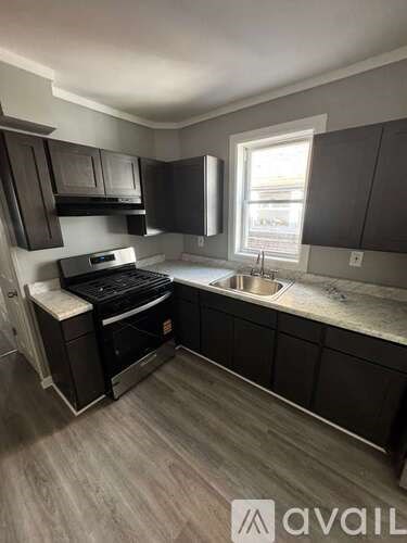 A kitchen with dark wood cabinets and a white countertop.